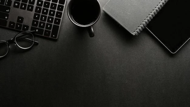 Laptop, coffee, glasses and notebooks arranged on a dark desk