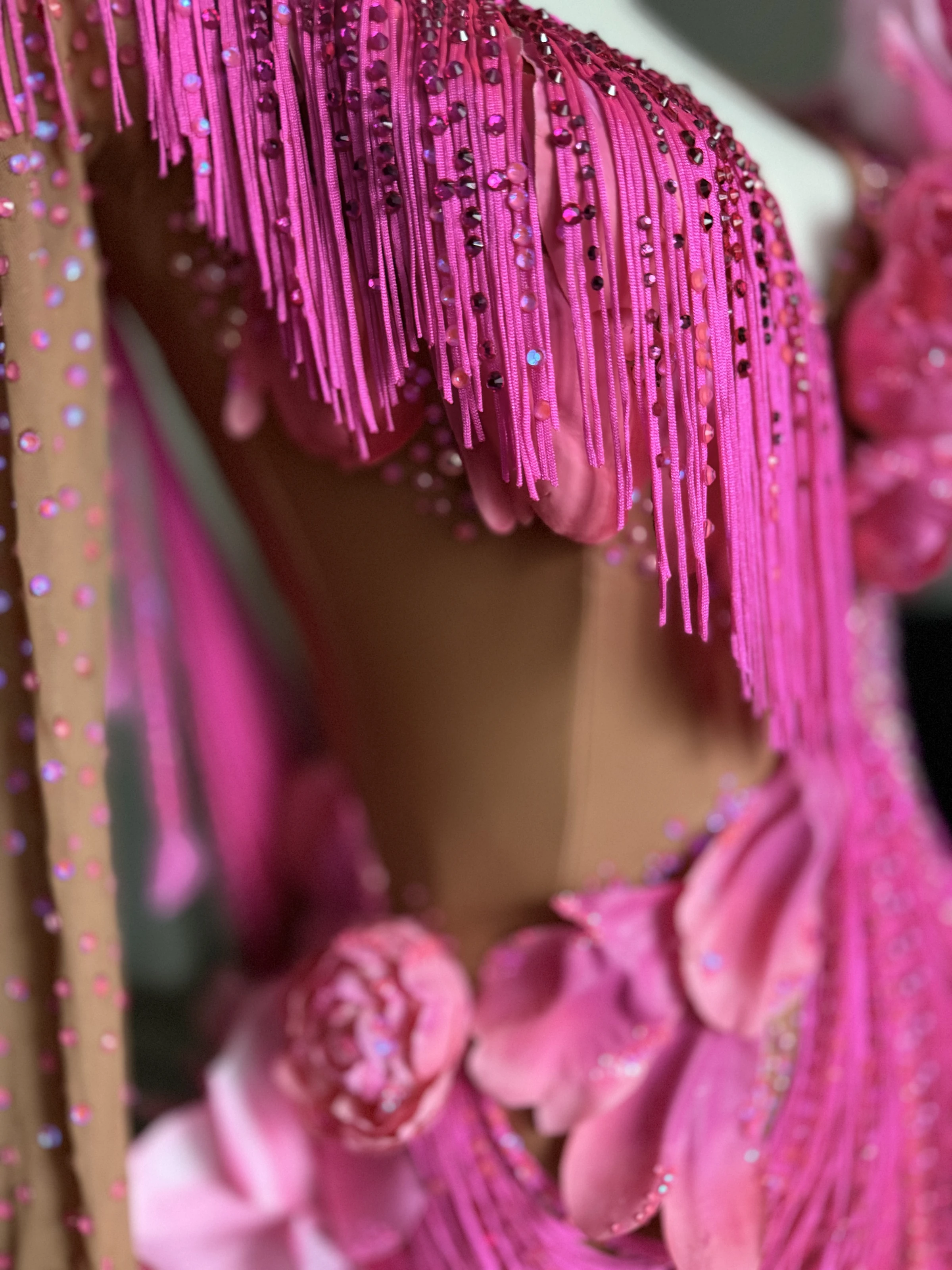 Layered pink fringe beside floral shoulder details