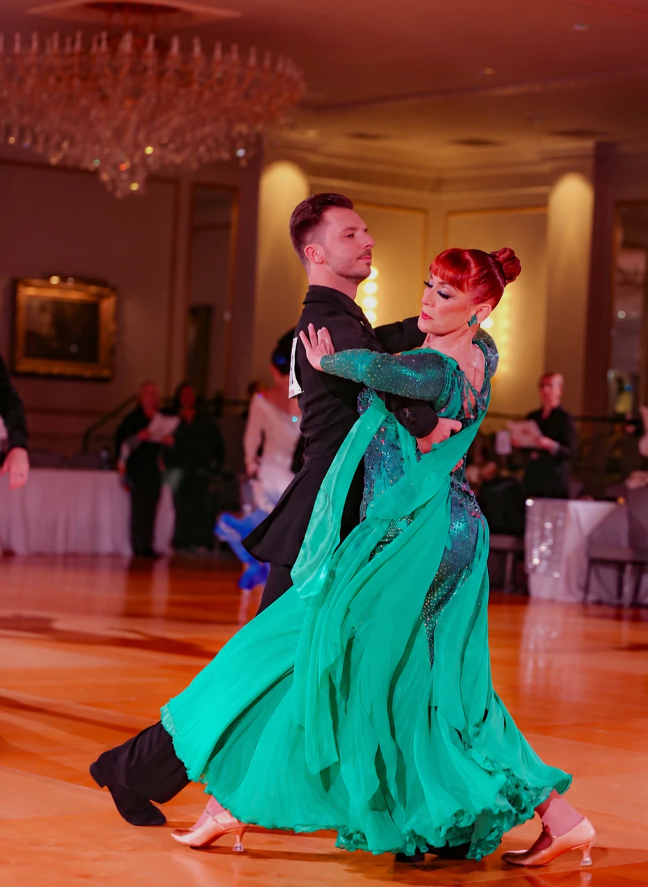 Dance couple performing with the green Aurora gown in motion